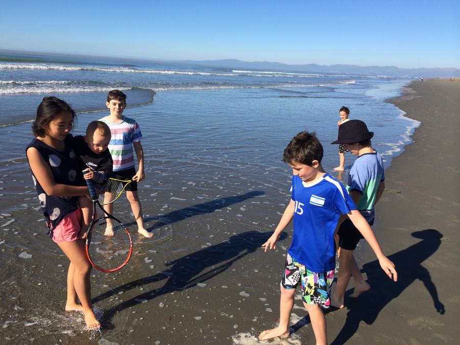 Children paddling at the water's edge on the beach