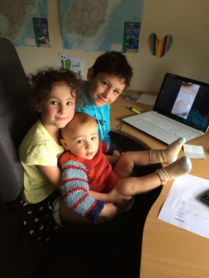 Children crowded around a laptop at the desk