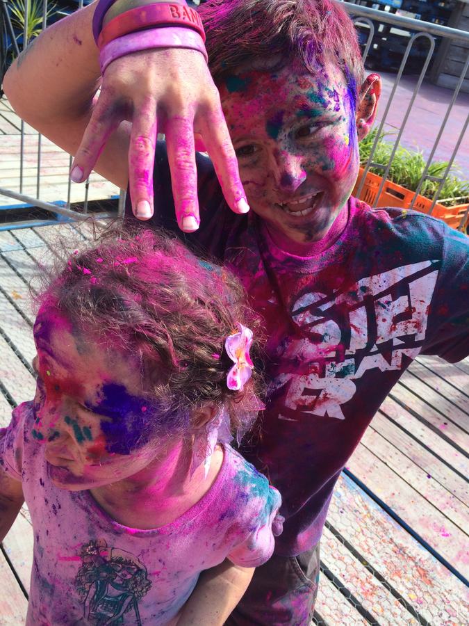 Hands covered in pink Holi powder held up to the camera