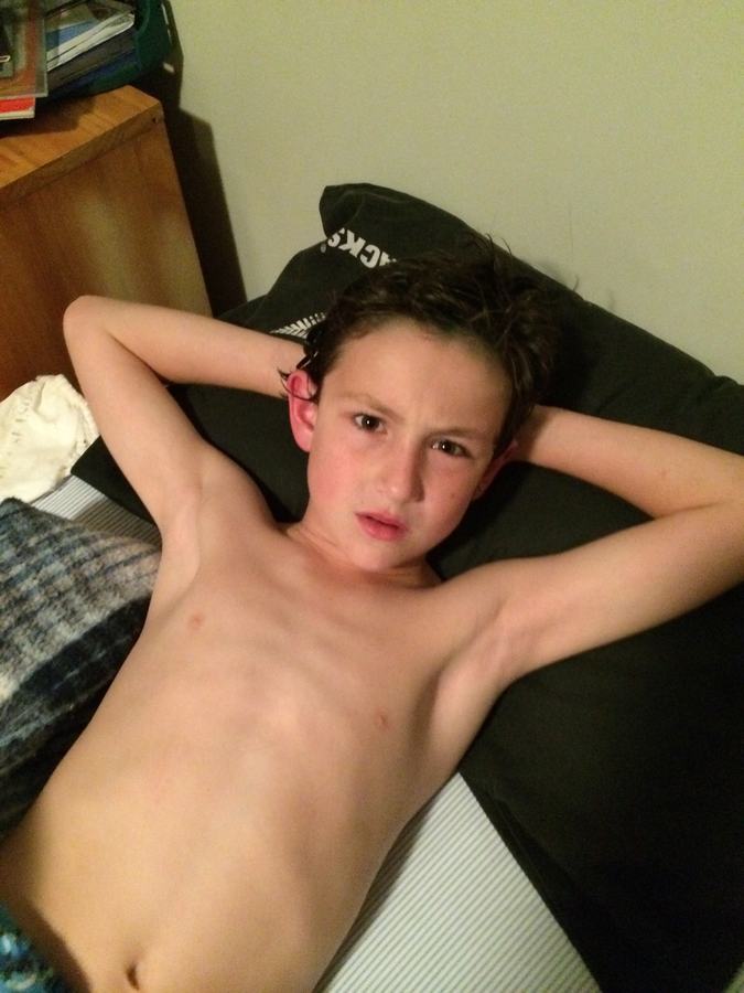 Boy resting on a bed at home