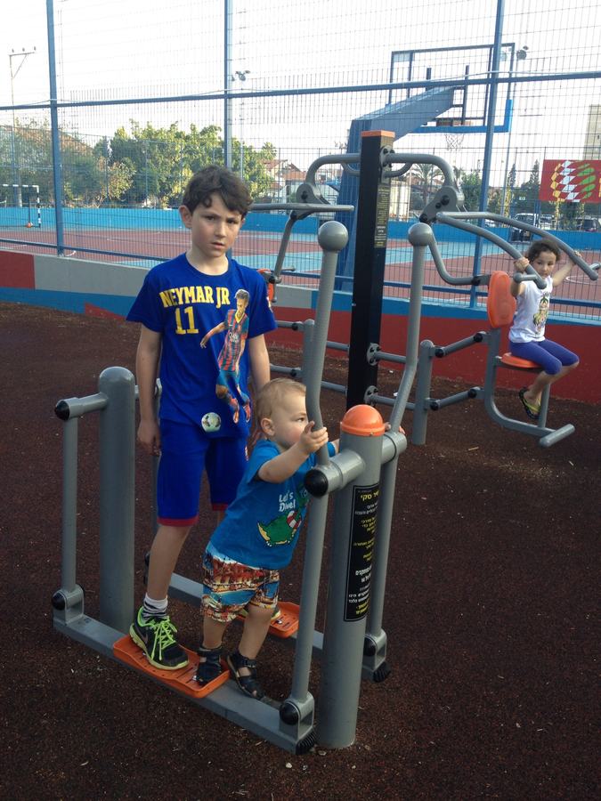 Boys climbing the exercise frame at an outdoor playground