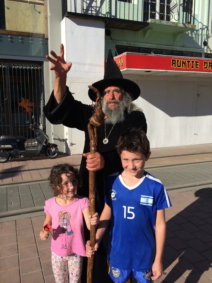 Kids posing with a costumed street performer in town