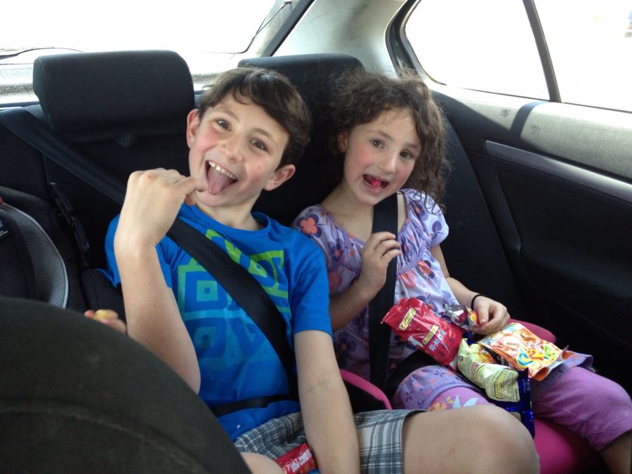 Children with snacks in the back of the car