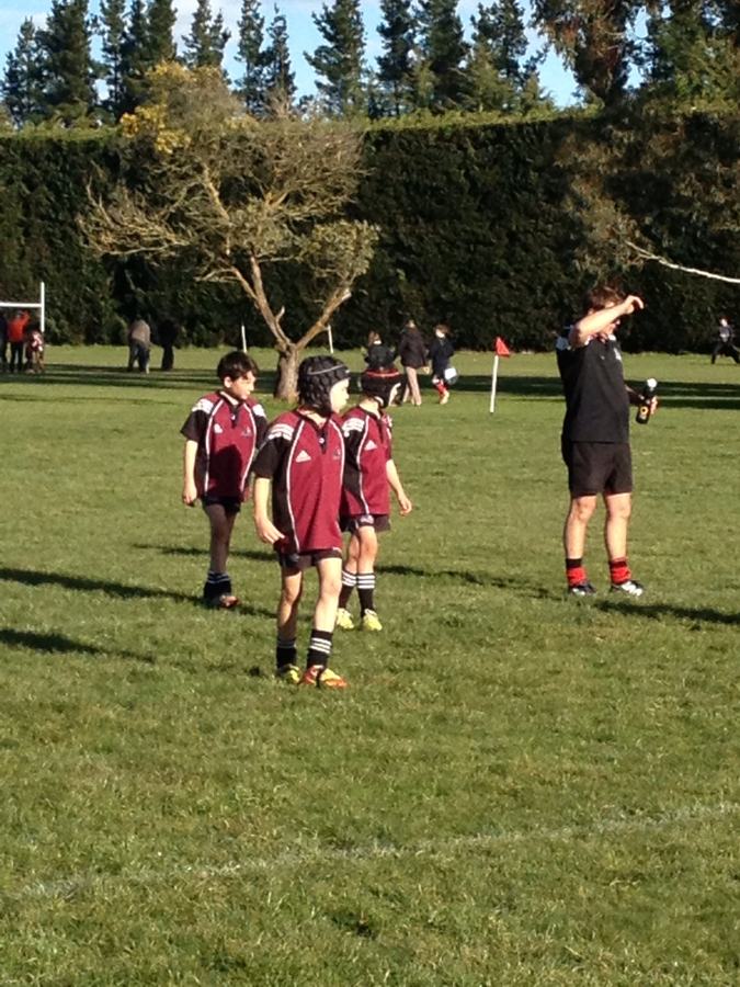 Junior rugby match on a grass field in the afternoon