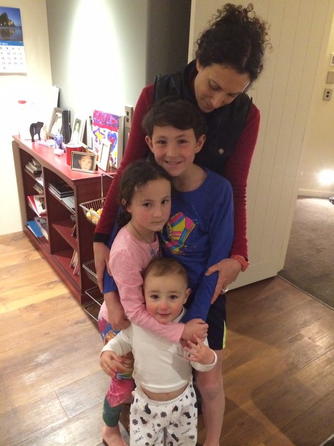 Mum and three children together beside the family shelves