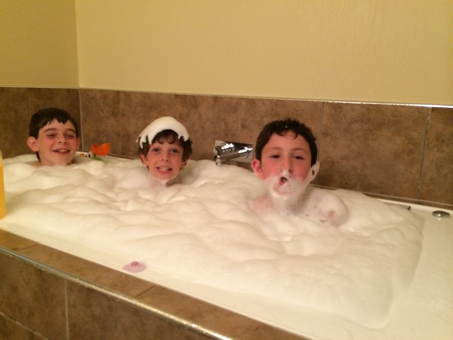 Two boys in a deep bubble bath