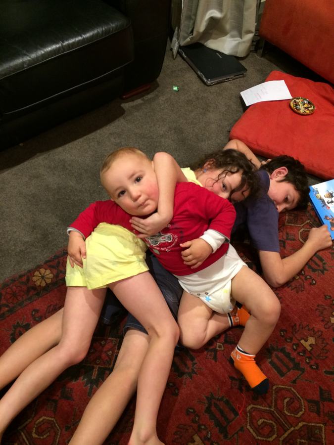 Children lying together on the rug at home