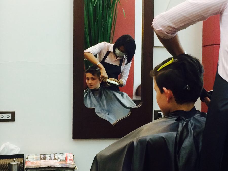 Boy having his hair cut in front of the mirror