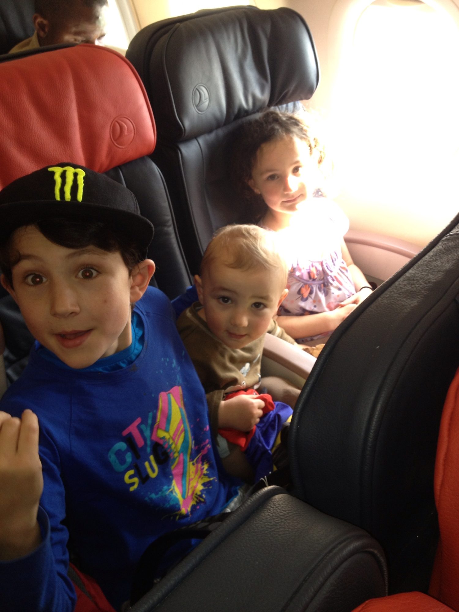Two children buckled into the back seat of the car